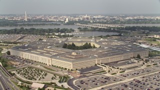 AX75_128E - 4.8K stock footage aerial video orbiting The Pentagon in Washington DC, with bridges over the Potomac in the background