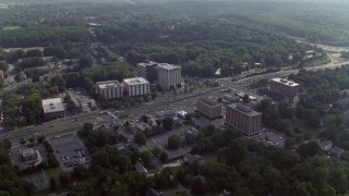 AX75_152 - 4.8K aerial stock footage of office buildings by a busy intersection in Annandale, Virginia