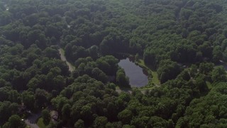 AX75_165 - 4.8K aerial stock footage of homes by pond on Havenner Road, surrounded by forest in Fairfax Station, Virginia