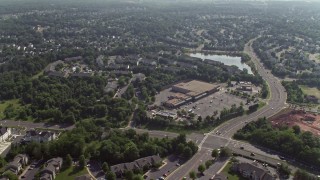 AX75_173E - 4.8K aerial stock footage flying over homes, row house, and a strip mall on Hasting Drive in Manassas, Virginia