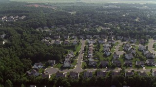 AX75_175 - 4.8K aerial stock footage flying over suburban homes to approach warehouse buildings in Manassas, Virginia