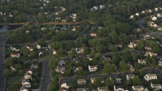 AX76_003 - 4.8K aerial stock footage tilting to bird's eye view of suburban homes in Manassas, Virginia, sunset