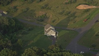 AX76_006 - 4.8K aerial stock footage flying by a home, green lawns, Manassas, Virginia, sunset
