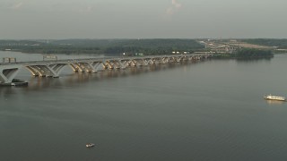 AX76_031E - 4.8K aerial stock footage of Woodrow Wilson Memorial Bridge, Potomac River, Fort Washington, Maryland, sunset