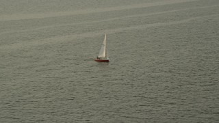 AX76_036 - 4.8K aerial stock footage tracking a sailboat on the Potomac River, Washington, D.C., sunset