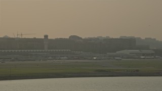 AX76_038 - 4.8K stock footage aerial video flying by Ronald Reagan Washington National Airport, Arlington, Virginia, sunset