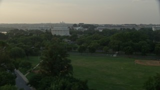 AX76_049 - 4.8K stock footage aerial video flying by Lincoln Memorial, seen from West Potomac Park, Washington D.C., sunset