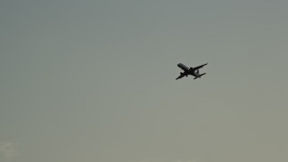 AX76_054 - 4.8K aerial stock footage tracking a commercial jet flying overhead, Washington D.C., sunset