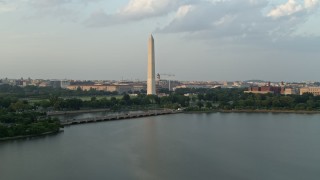 AX76_060 - 4.8K aerial stock footage of Washington Monument seen from Tidal Basin, Washington D.C., sunset