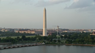 AX76_061 - 4.8K aerial stock footage of Washington Monument seen from Tidal Basin, Washington D.C., sunset
