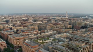 AX76_075 - 4.8K aerial stock footage of the Washington Monument over office and apartment buildings, Washington D.C., sunset