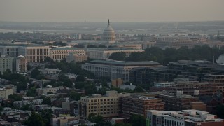 AX76_087 - 4.8K aerial stock footage of the United States Capitol dome behind Senate Office Buildings, Washington D.C., sunset