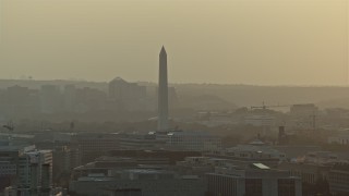 AX76_092 - 4.8K aerial stock footage of the Washington Monument and office buildings in Washington D.C., sunset