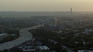 AX76_094 - 4.8K stock footage aerial video of Interstate 695, Capitol Power Plant, and Washington Monument, Washington D.C., sunset