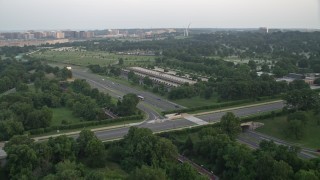 AX76_112 - 4.8K stock footage aerial video approaching parking structure and Visitors Center at Arlington National Cemetery, Virginia, sunset