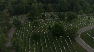 AX76_118 - 4.8K aerial stock footage flying over Arlington National Cemetery, tilt to gravestones, Virginia, twilight
