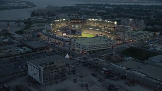 AX76_170E - 4.8K stock footage aerial video approaching Nationals Park during a baseball game, Washington, D.C., twilight