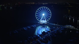 AX77_018 - 4.8K aerial stock footage of the Capitol Wheel and the National Harbor Marina, Maryland, night