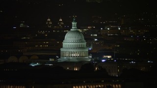 AX77_030E - 4.8K aerial stock footage of the United States Capitol and Thomas Jefferson Building domes in Washington, D.C., night