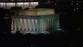 AX77_049E - 4.8K aerial stock footage of the Lincoln Memorial with visitors on the steps in Washington, D.C., night