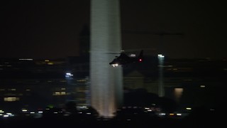 AX77_055 - 4.8K aerial stock footage tracking a helicopter flying over National Mall, Washington, D.C., night