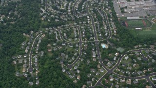AX78_033E - 4.8K aerial stock footage of a reverse view of suburban homes, roads, trees, Herndon, Virginia