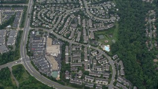 AX78_038E - 4.8K aerial stock footage of a reverse view of suburban homes, reveal Great Falls Plaza in Sterling, Virginia