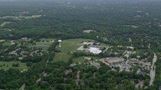 AX78_065E - 4.8K aerial stock footage of Harper's Choice Middle School, Joseph Square Shopping Center, and suburban homes in Columbia, Maryland