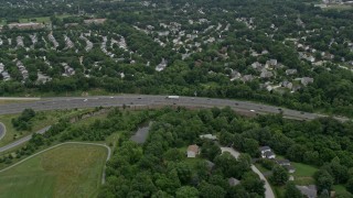 AX78_071E - 4.8K aerial stock footage flying over suburban neighborhoods and Highway 100 to approach park in Ellicott City, Maryland