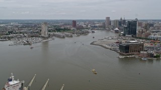 AX78_106E - 4.8K aerial stock footage flying over cargo ship to approach Inner Harbor area of Downtown Baltimore, Maryland