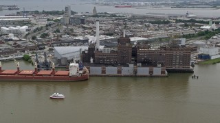 AX78_113 - 4.8K aerial stock footage of Domino Sugar Factory and a docked cargo ship in Baltimore, Maryland