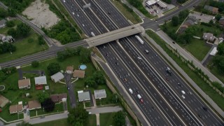 AX78_125 - 4.8K aerial stock footage tilting from a bird's eye of light traffic on Interstate 95 in Baltimore, Maryland, to reveal suburban neighborhoods
