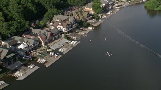 AX79_063E - 4.8K aerial stock footage of rowers on the Schuylkill River by Boathouse Row, Philadelphia, Pennsylvania