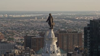 AX80_034 - 4.8K aerial stock footage approaching the William Penn statue atop Philadelphia City Hall, Pennsylvania, Sunset