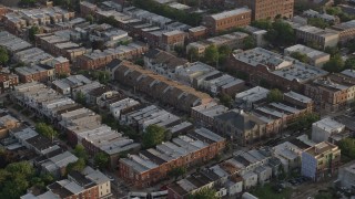 AX80_052 - 4.8K stock footage aerial video flying by row houses in North Philadelphia, Pennsylvania, Sunset