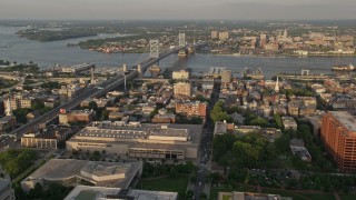 AX80_059 - 4.8K aerial stock footage flying over office buildings and by Benjamin Franklin Bridge, Philadelphia, Pennsylvania, Sunset