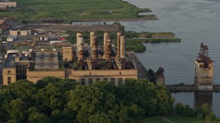 AX80_073 - 4.8K aerial stock footage of an abandoned factory by the Delaware River, North Philadelphia, Pennsylvania Sunset