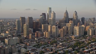 AX80_092E - 4.8K aerial stock footage of Downtown Philadelphia skyscrapers and urban neighborhoods in Pennsylvania, Sunset