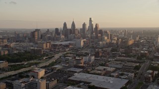 AX80_097E - 4.8K aerial stock footage of Downtown Philadelphia skyline and the I-676 freeway, Pennsylvania, at sunset