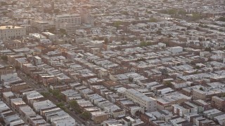 AX80_111 - 4.8K aerial stock footage flying by an urban neighborhood in South Philadelphia and tilt to the busy street, Pennsylvania, Sunset