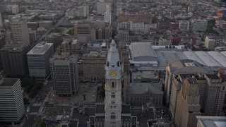 AX80_115E - 4.8K aerial stock footage approaching Philadelphia City Hall's William Penn statue, Downtown Philadelphia, Pennsylvania, Sunset