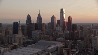 AX80_143 - 4.8K aerial stock footage flying by tall skyscrapers in Downtown Philadelphia skyline, Pennsylvania, Sunset
