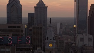 AX80_156 - 4.8K aerial stock footage of the William Penn statue on Philadelphia City Hall, Pennsylvania, and setting sun in the background