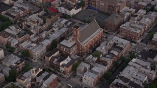 AX80_158 - 4.8K aerial stock footage of Saint Paul Church in an urban neighborhood, South Philadelphia, Pennsylvania, Sunset