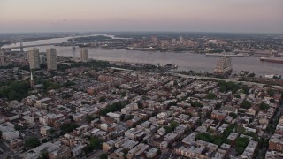 AX80_159 - 4.8K aerial stock footage flying over South Philly to approach Delaware River and Camden, New Jersey, Sunset