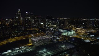 AX81_050E - 4.8K aerial stock footage of orbit bridges over the Schuylkill River by Cira Centre, I-76 and train yard, reveal Downtown Philadelphia, Pennsylvania, Night