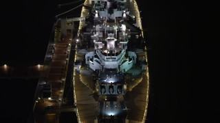 AX81_083E - 4.8K aerial stock footage of the USS New Jersey in Camden, New Jersey, Night