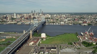 AX82_002 - 4.8K aerial stock footage of Benjamin Franklin Bridge spanning the Delaware River near the Downtown Philadelphia skyline, Pennsylvania
