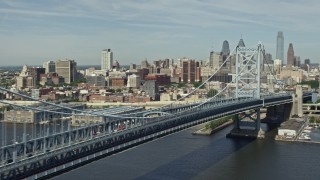 AX82_003E - 4.8K aerial stock footage panning across Benjamin Franklin Bridge to reveal Downtown Philadelphia skyline, Pennsylvania
