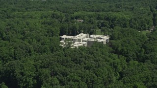 AX82_105 - 4.8K aerial stock footage of an apartment complex partially hidden by trees in Princeton, New Jersey